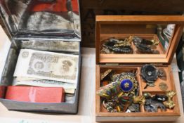 A wooden box of costume jewellery and a tin of bank notes and coins.