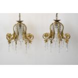 A pair of hanging ceiling lights with scrolling gilt metal frames and crystal drops. H.62 W.30cm.