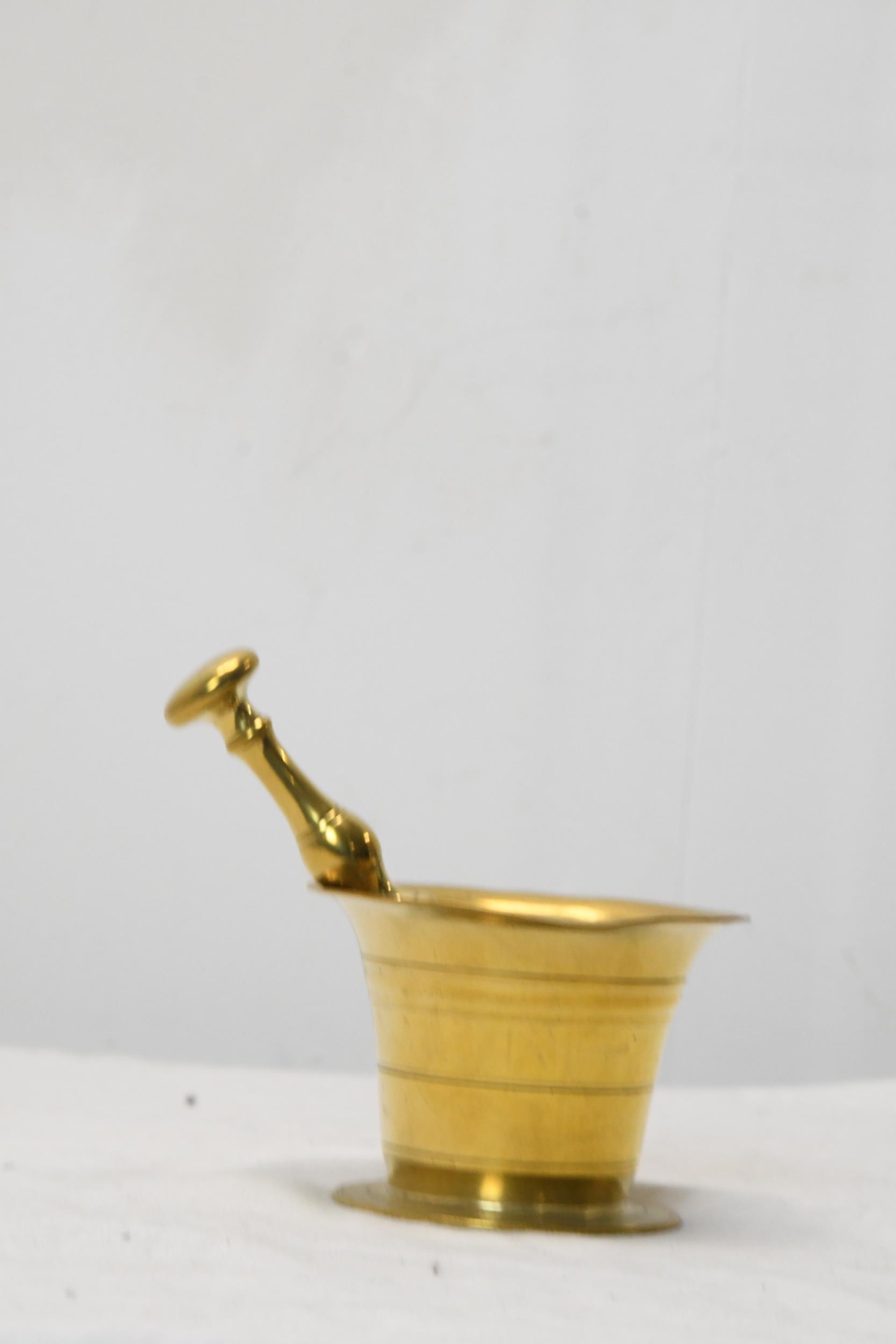 An early 20th century brass pestle and mortar. Pestle is 16cm long, mortar is H.8 W.10 D.10cm. - Image 2 of 4