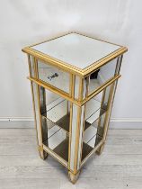 A mirrored glass and gilt pedestal cabinet. H.90 W.40 D.40cm.