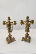 A pair of early 20th century Gothic style gilt metal four branch candelabras with hand painted