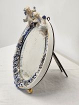 An early 20th century Sitzendorf hand painted relief cherub mirror with sculpted flower detailing.