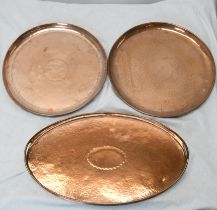 Three large Arts ands Crafts hammered copper trays, one of oval form with twin handles. The pair