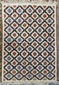 A woollen carpet with allover geometric pattern on an ivory field. L.230 W.195cm.