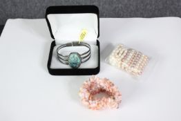 A collection of bracelets, including a boxed silver and turquoise bangle, three elasticated cultured