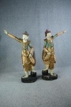 A pair of carved floor standing Chinese goddesses. In heavily detailed gilt decorated robes and