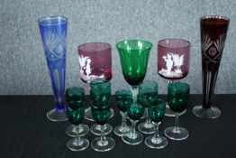 A mixed collection of coloured glasses, including a pair of Mary Gregory goblets.