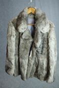 A vintage grey rabbit fur short winter coat with grey silk lining. The coat has a wide collar.
