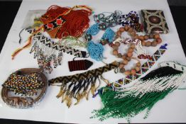 A collection of tribal beaded jewellery, including necklaces, belts and bracelets. With various