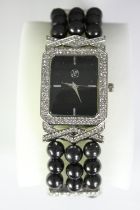 A boxed Geona fashion watch with faux black pearl elastic strap and diamante stones to the face
