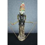 A vintage Indonesian carved and painted puppet. With a well decorated headdress and fabric dress.