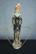 A vintage Indonesian carved and painted puppet. With a well decorated headdress and fabric dress.