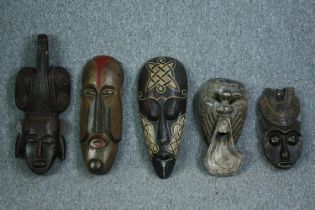 A miscellaneous collection of five Eastern and Tribal masks. H.60cm. (largest)