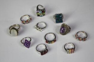 A collection of eleven silver gem-set rings of various designs. Set with peridot, aquamarine, Opal