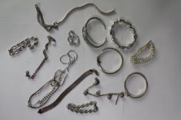 A collection of silver bangles and chain link bracelets, various designs and lengths. All stamped