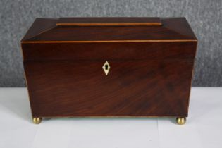 A Regency mahogany and satinwood strung tea caddy with fitted lidded compartments and a mixing bowl.