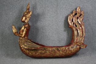 A large carved Buddha in a boat or canoe. Gilded and decorated with small mirror tiles. H.125 W.