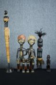 Four carved African figures including a seated pair. The smaller of the collection is seated and