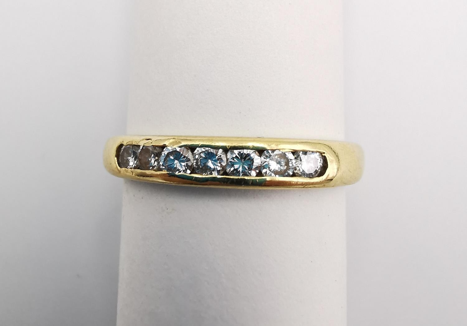 An 18ct yellow gold diamond seven stone half eternity style ring. Set with seven round brilliant cut