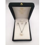 A boxed pair of 9ct white gold pearl and diamond earrings along with a pearl and diamond pendant and