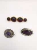 A red paste foil backed rolled gold brooch, along with a purple paste silver cluster brooch and an