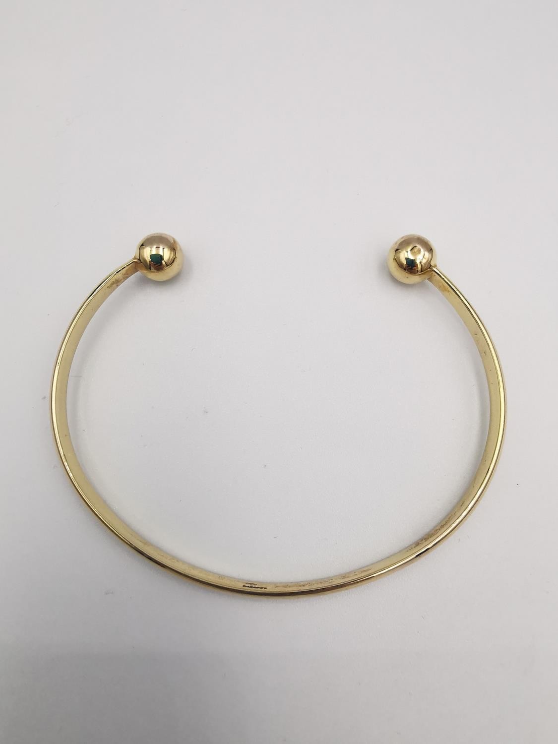 A 9ct yellow gold D-shaped bangle with ball ends. Hallmarked for 9ct. Weight.11.42g Dia.7cm - Image 3 of 6