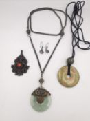 A collection of Chinese jewellery, including a jade Bi disc pendant, a silver and coral fish pendant