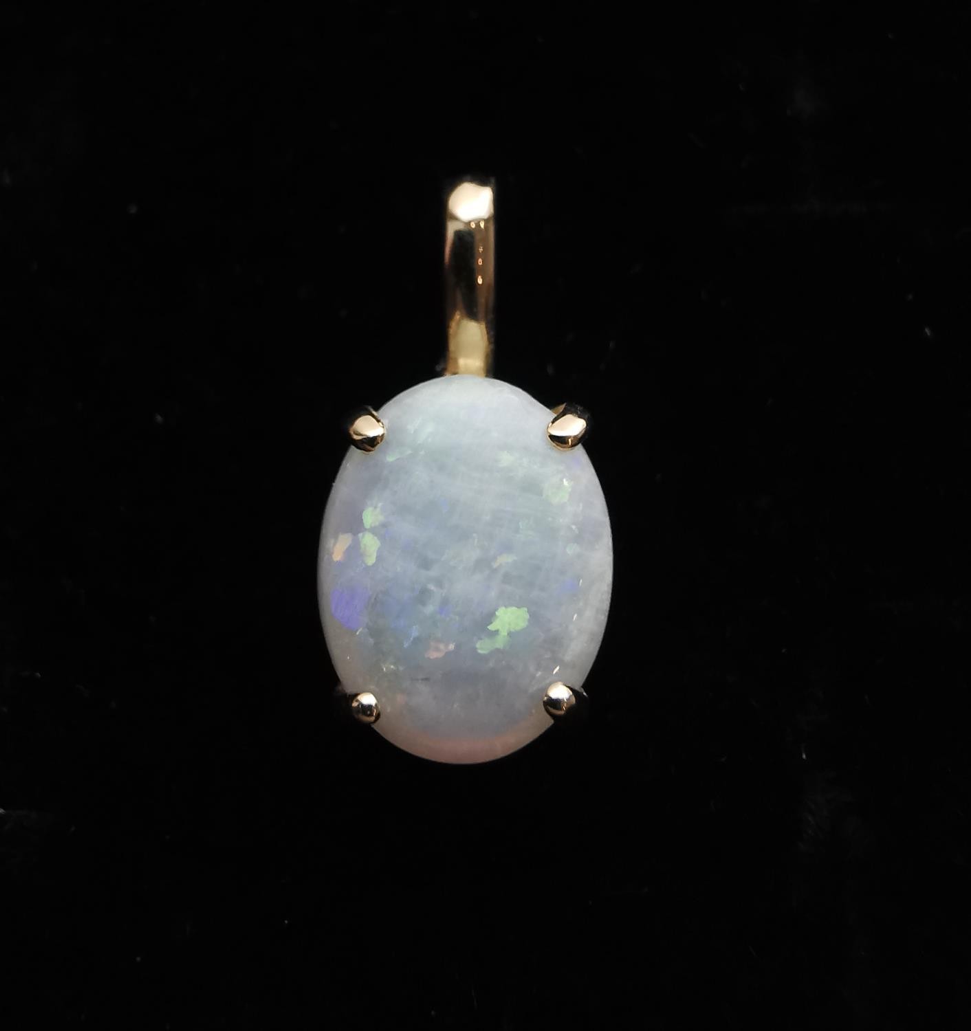 An 18ct yellow gold mounted opal pendant. The pendant set with an oval opal cabochon in an open back - Image 8 of 8