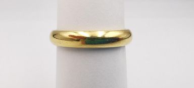 An 18ct yellow gold court shape band. Hallmarked: CPM, Birmingham, 750, 2005. Ring size V. Weight