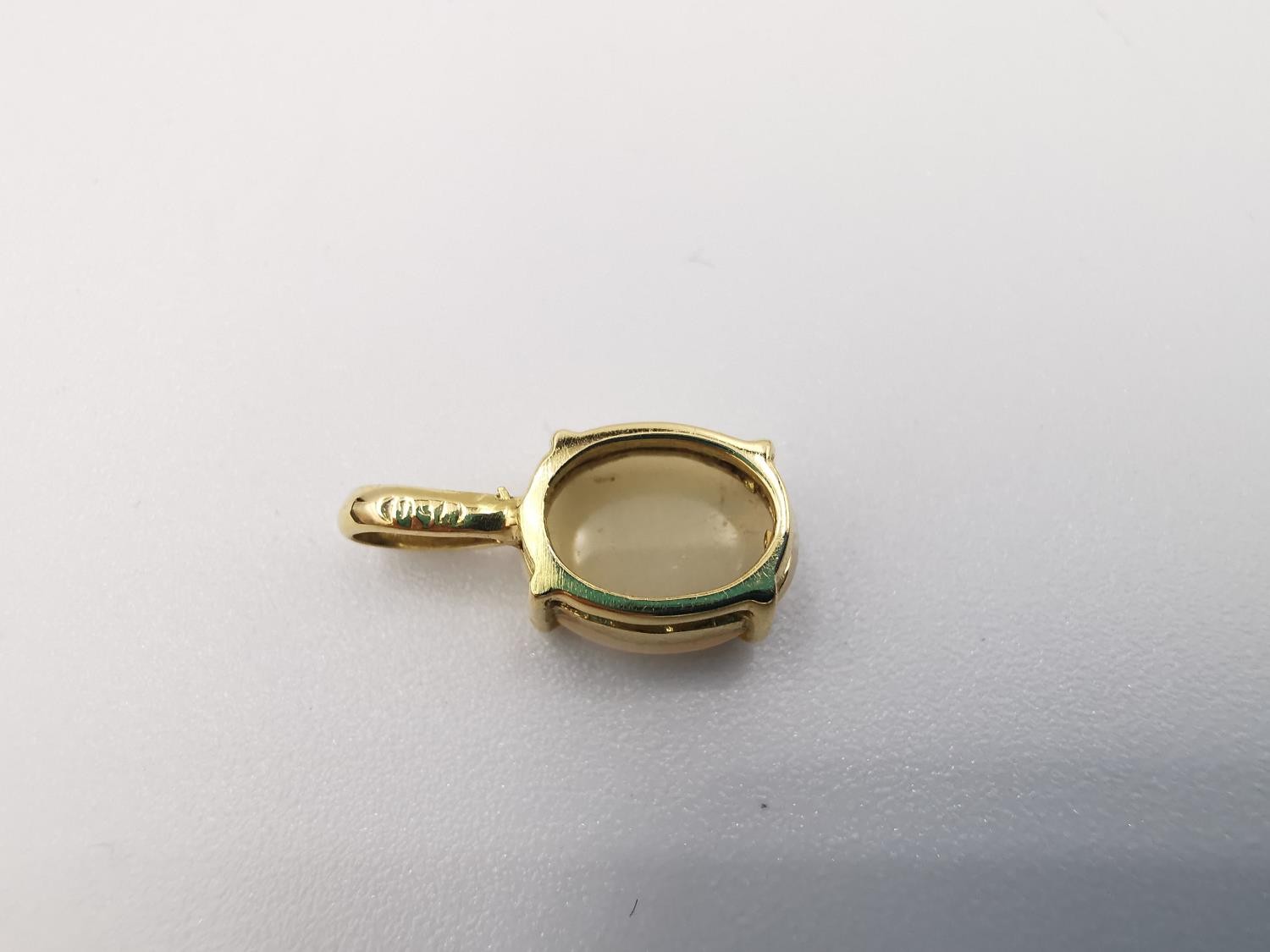 An 18ct yellow gold mounted opal pendant. The pendant set with an oval opal cabochon in an open back - Image 5 of 8