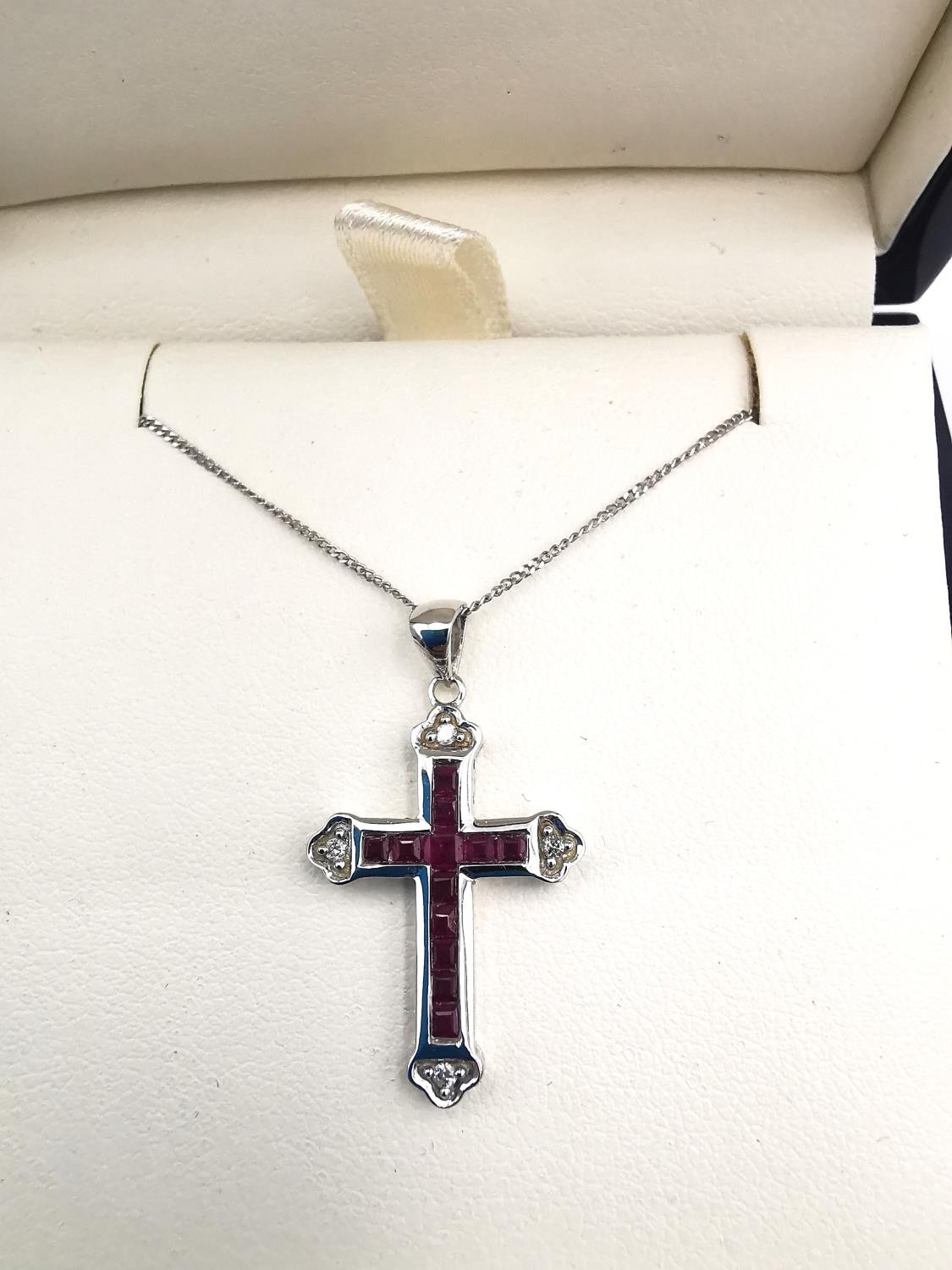 A boxed 9ct white gold ruby and diamond cross and chain. The cross set with twelve square channel - Image 2 of 7