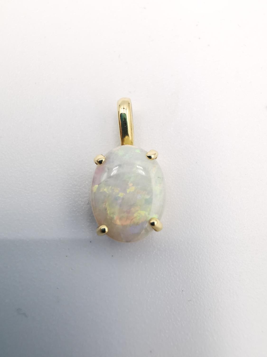 An 18ct yellow gold mounted opal pendant. The pendant set with an oval opal cabochon in an open back - Image 3 of 8