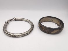 Two silver bracelets, a silver rope chain bracelet and a hollow silver clip bangle with engraved