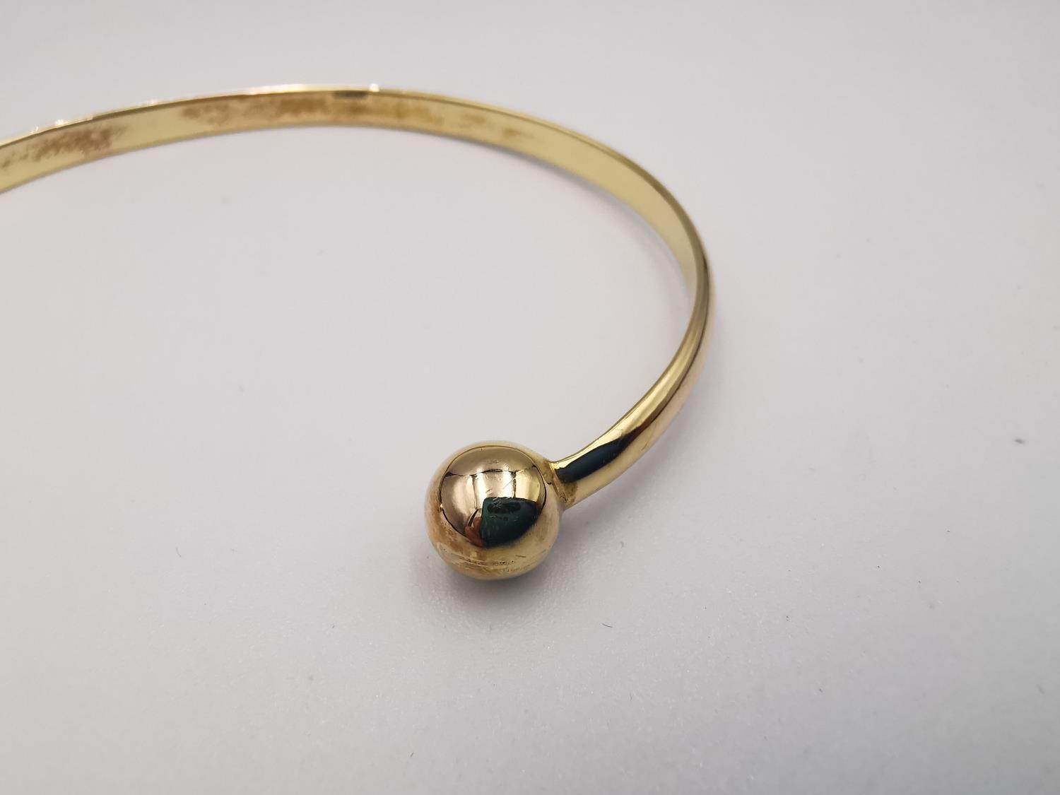 A 9ct yellow gold D-shaped bangle with ball ends. Hallmarked for 9ct. Weight.11.42g Dia.7cm - Image 6 of 6