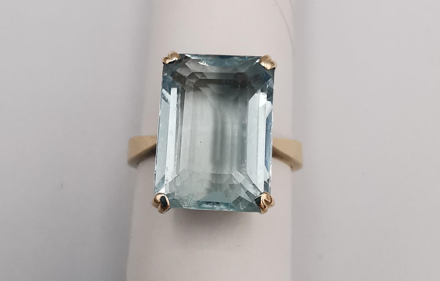 A yellow metal (tests higher than 9ct) aquamarine dress ring, set with a rectangular step cut