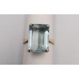 A yellow metal (tests higher than 9ct) aquamarine dress ring, set with a rectangular step cut