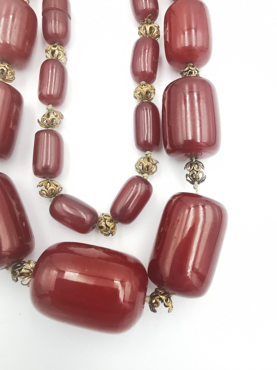 An early 20th century long cherry amber Bakelite graduated bead necklace. In between each Bakelite - Image 2 of 4
