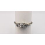 A boxed diamond platinum and 18ct white gold three stone ring. Set with three round old cut diamonds