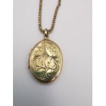 A 9ct yellow box chain and 9ct yellow gold engraved oval locket. The oval locket with a stylised