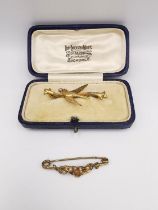 Two Victorian yellow metal and seed pearl brooches, a leather cased 9ct and seed pearl swallow bar
