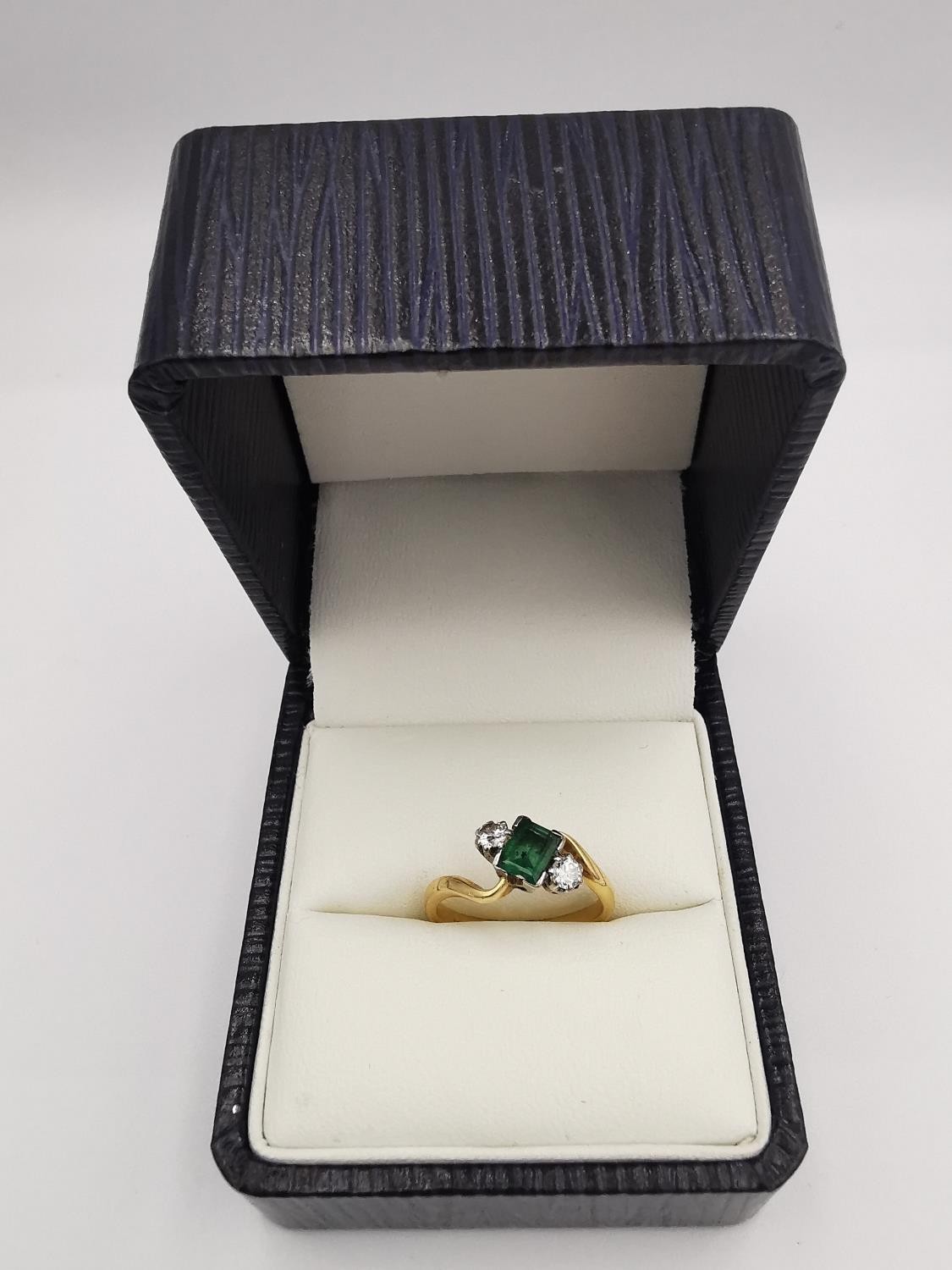 An Edwardian 18ct yellow gold and white metal emerald and diamond cross over ring. Set to centre - Image 2 of 4