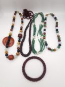 A collection of gemstone jewellery, including a garnet bead rope necklace and bangle, a green