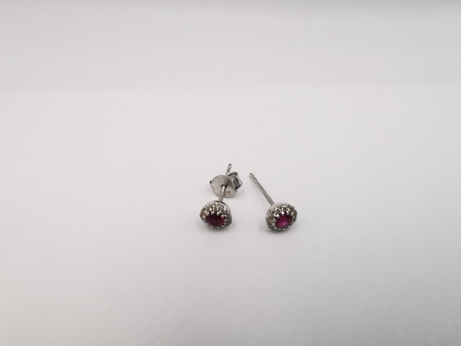 A pair of 18ct white gold ruby and diamond cluster stud earrings. Each set to centre with a round - Image 2 of 6