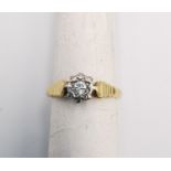 An 18ct yellow and white gold diamond solitaire ring. Set to centre with a round brilliant cut