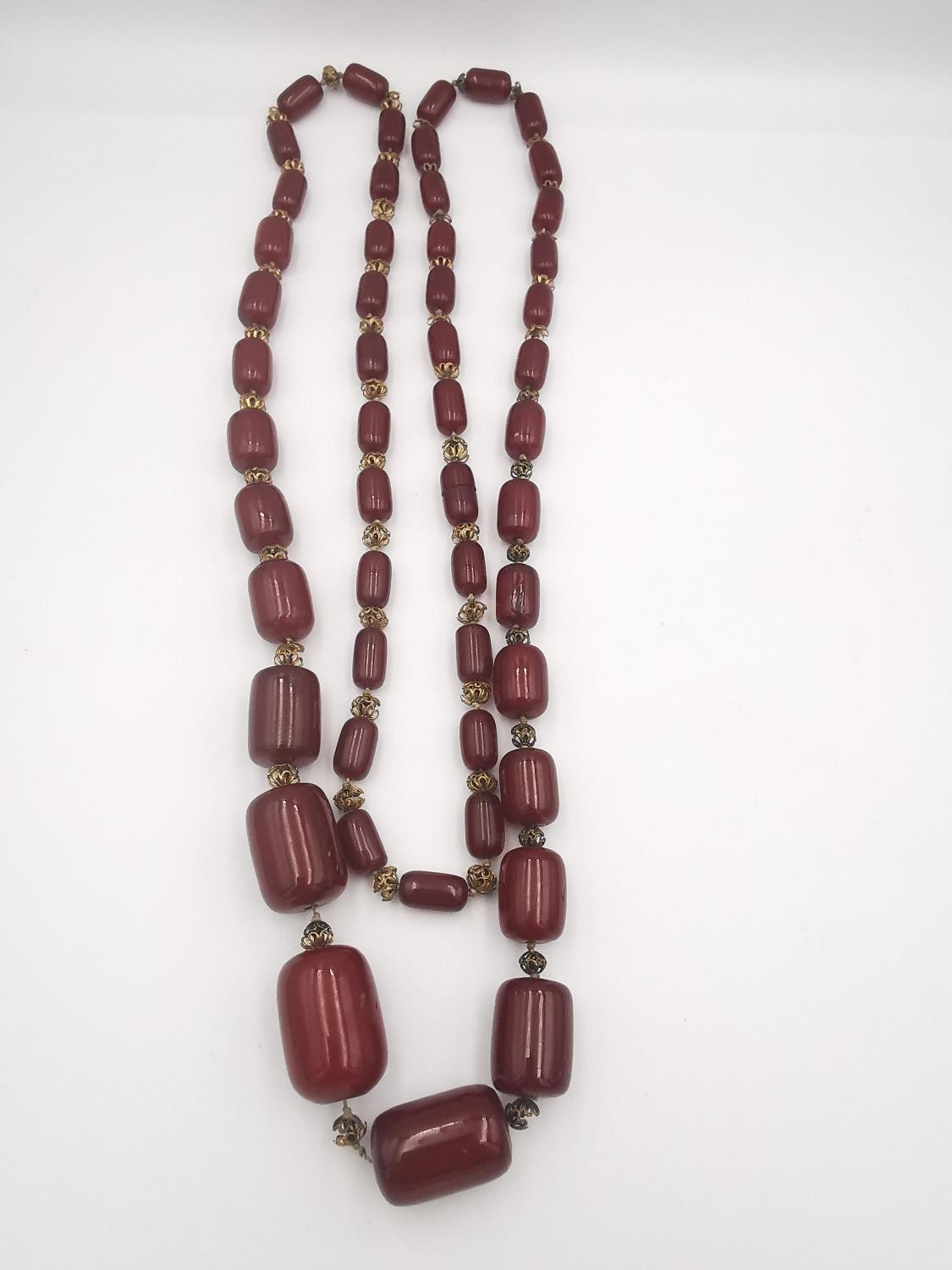 An early 20th century long cherry amber Bakelite graduated bead necklace. In between each Bakelite - Image 4 of 4