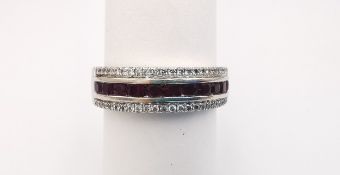 An 18ct white gold ruby and diamond half eternity ring, set with a channel of eleven oval mixed