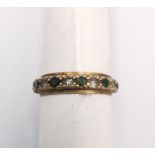 A 9ct yellow gold full eternity ring set with cubic zirconia and green paste stones. Stamped 9ct.