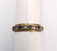 A 9ct yellow gold full eternity ring set with cubic zirconia and green paste stones. Stamped 9ct.