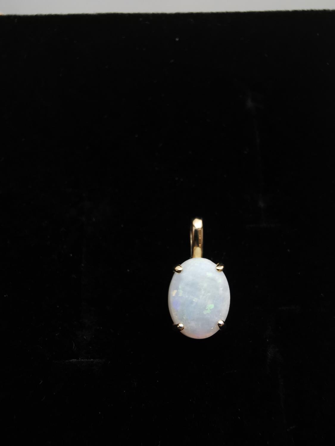 An 18ct yellow gold mounted opal pendant. The pendant set with an oval opal cabochon in an open back - Image 7 of 8