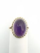 A 9ct yellow gold amethyst dress ring, set with an oval amethyst cabochon with an approximate